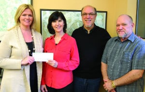 Amy Saxe of OPALCO's Energy Services program presents a check to Linda Lyshall for the San Juan Islands Conservation District. Also pictured: Jay Kimball, consultant, and Randy J. Cornelius, General Manager of OPALCO.