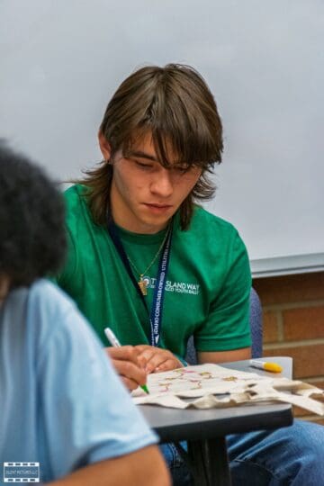 Gabe Chapman decorating a tote bag