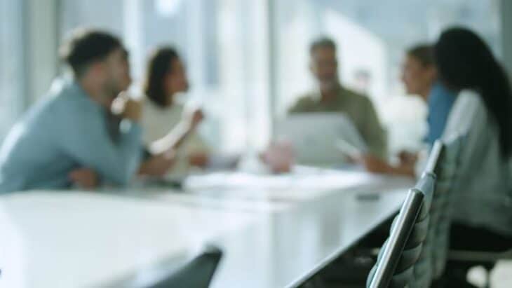 Photo of people having a meeting around a board room table.