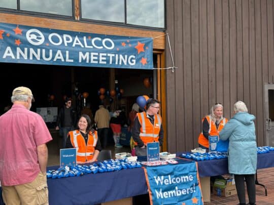 Los representantes de atención al cliente de OPALCO dan la bienvenida a los socios al evento.